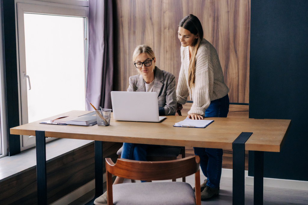 Two People Going Over Job Postings On A Computer