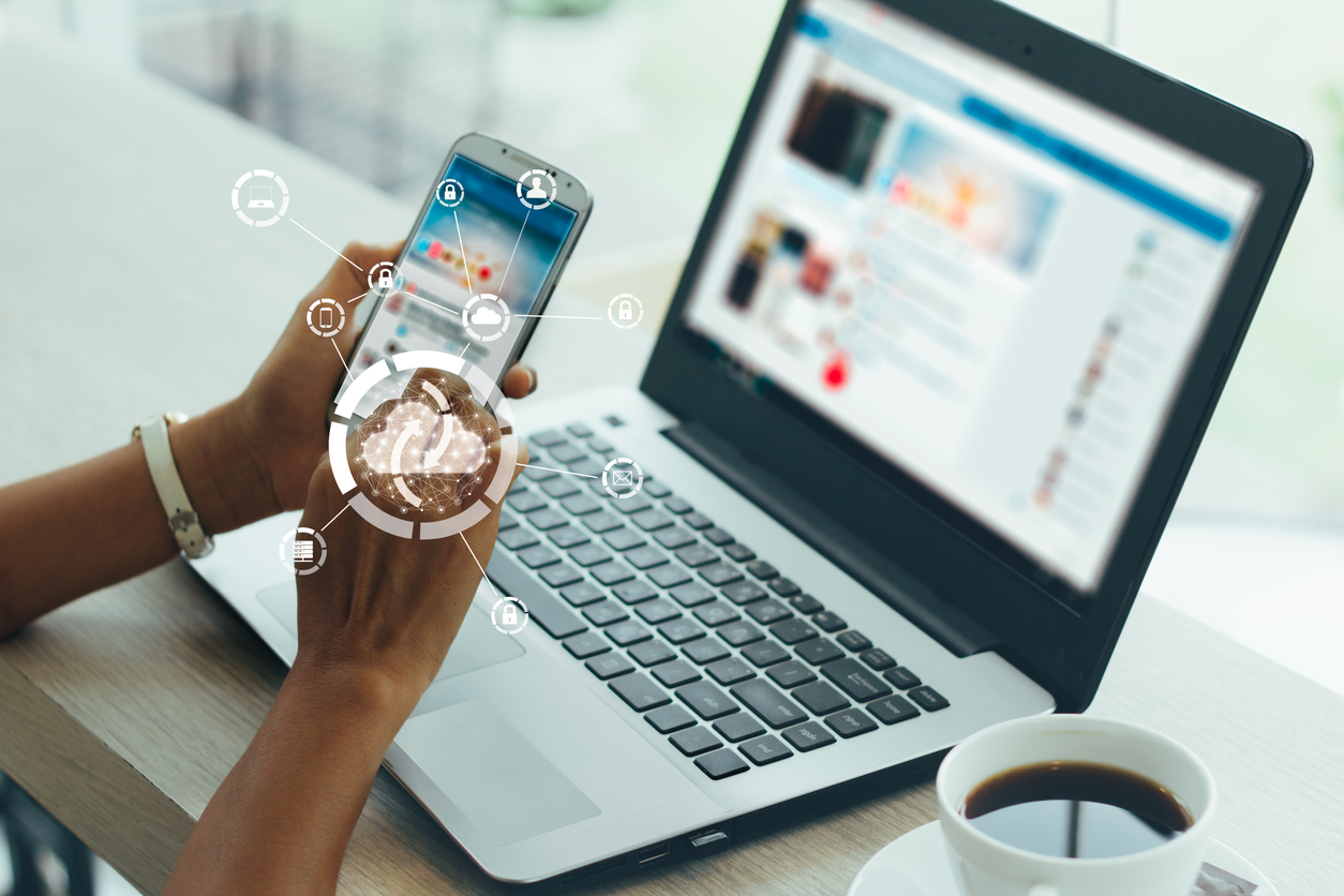 Young businesswoman working on his smartphone and laptop in the office, select the icon cloud on the virtual display.Concept digital technology and cloud technology.vintage color tones