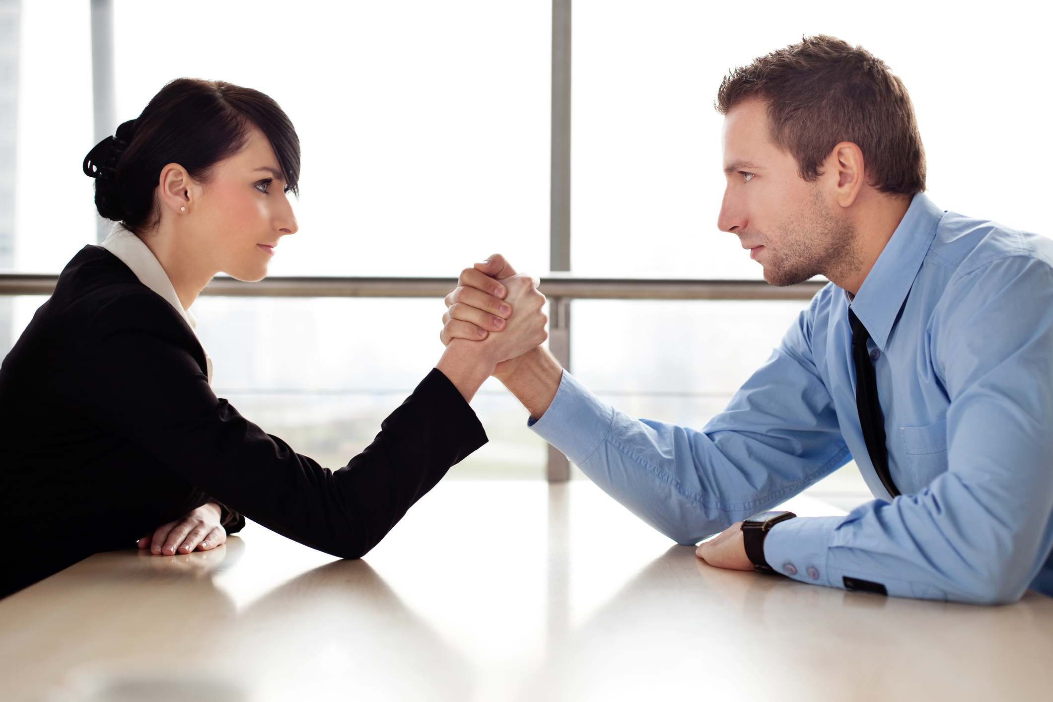 Businessman and businesswoman arm wrestling