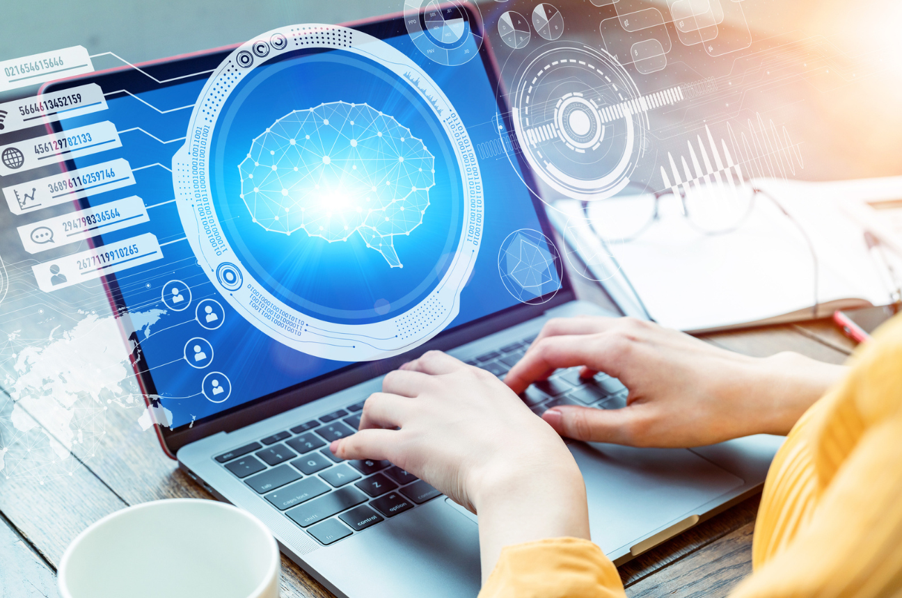 A woman's hands typing on a notebook computer, a futuristic digital display pops off the screen to represent using AI in recruitment